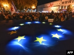 Проевропейский митинг прошел на центральной площади Свободы в Тбилиси 20 октября. Десятки тысяч демонстрантов размахивают флагами ЕС и Грузии и держат плакаты с "Грузия выбирает Европейский Союз". Фото AFP