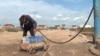 Kazakhstan -- a local resident of Astana fills bottles with water because of the lack of public infrastructure